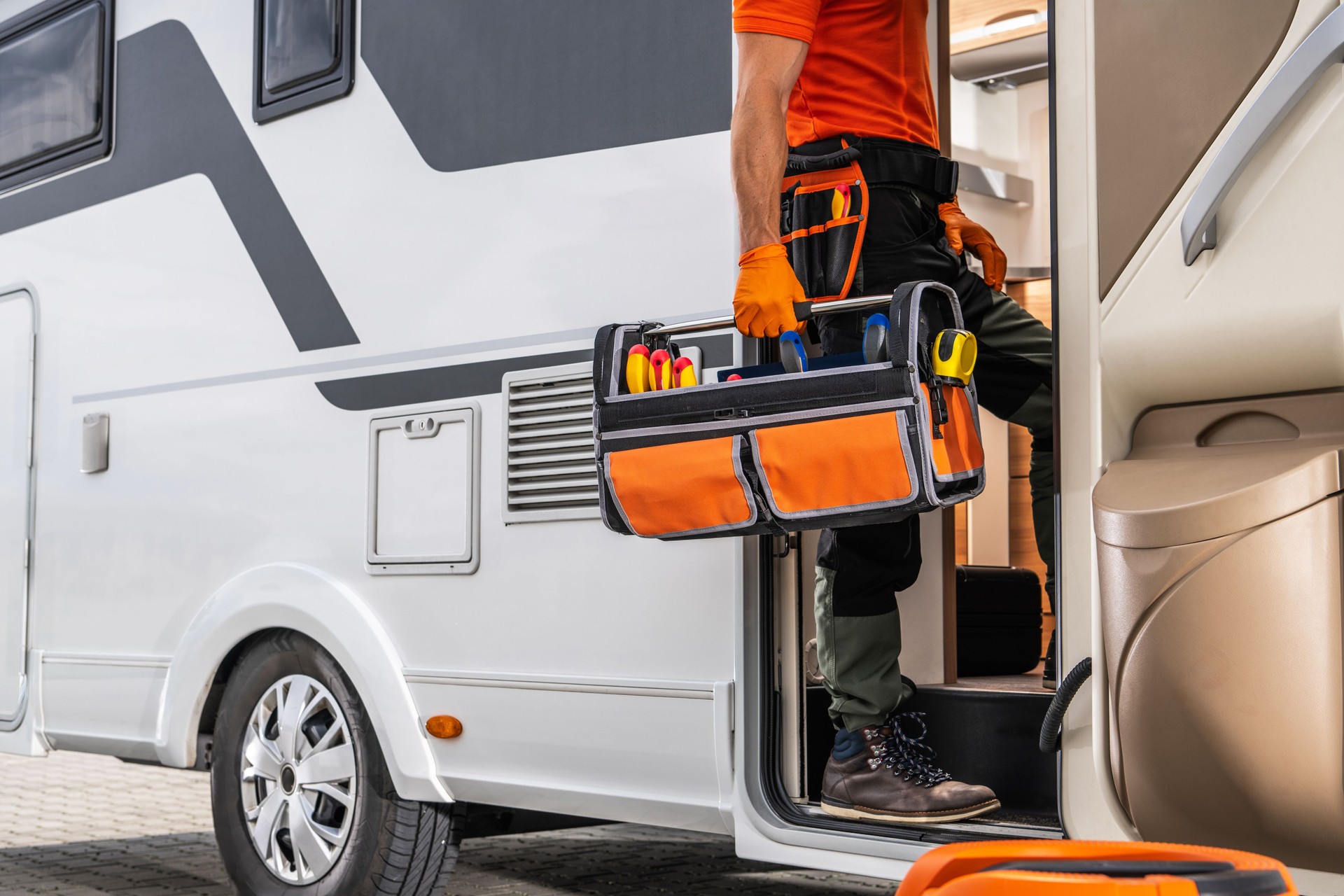 RV Technician Entering a Motorhome With Toolbox